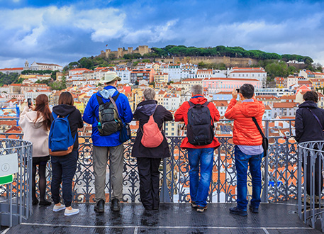 Group of travelers overlooking a colorful European city from a scenic viewpoint